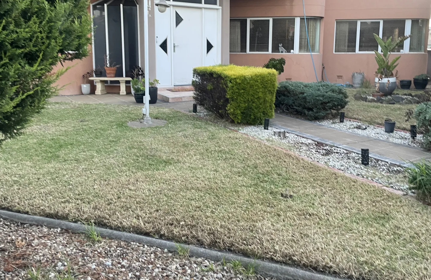 A tidy front yard in Altona featuring a short, freshly trimmed lawn