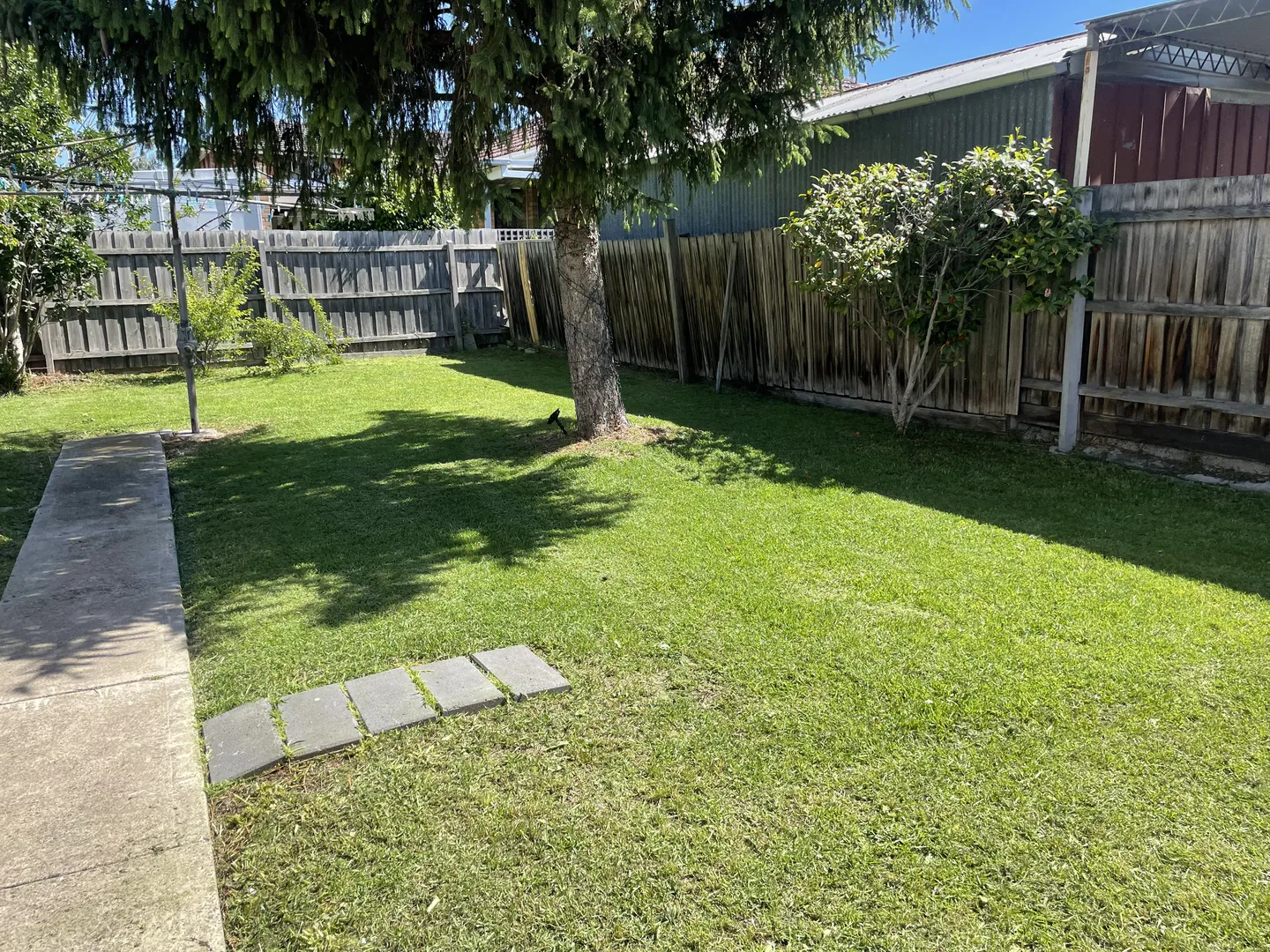 A spacious backyard lawn with evenly trimmed green grass