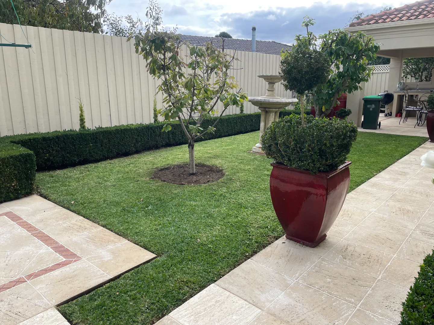 A residential backyard with a freshly cut green grass lawn