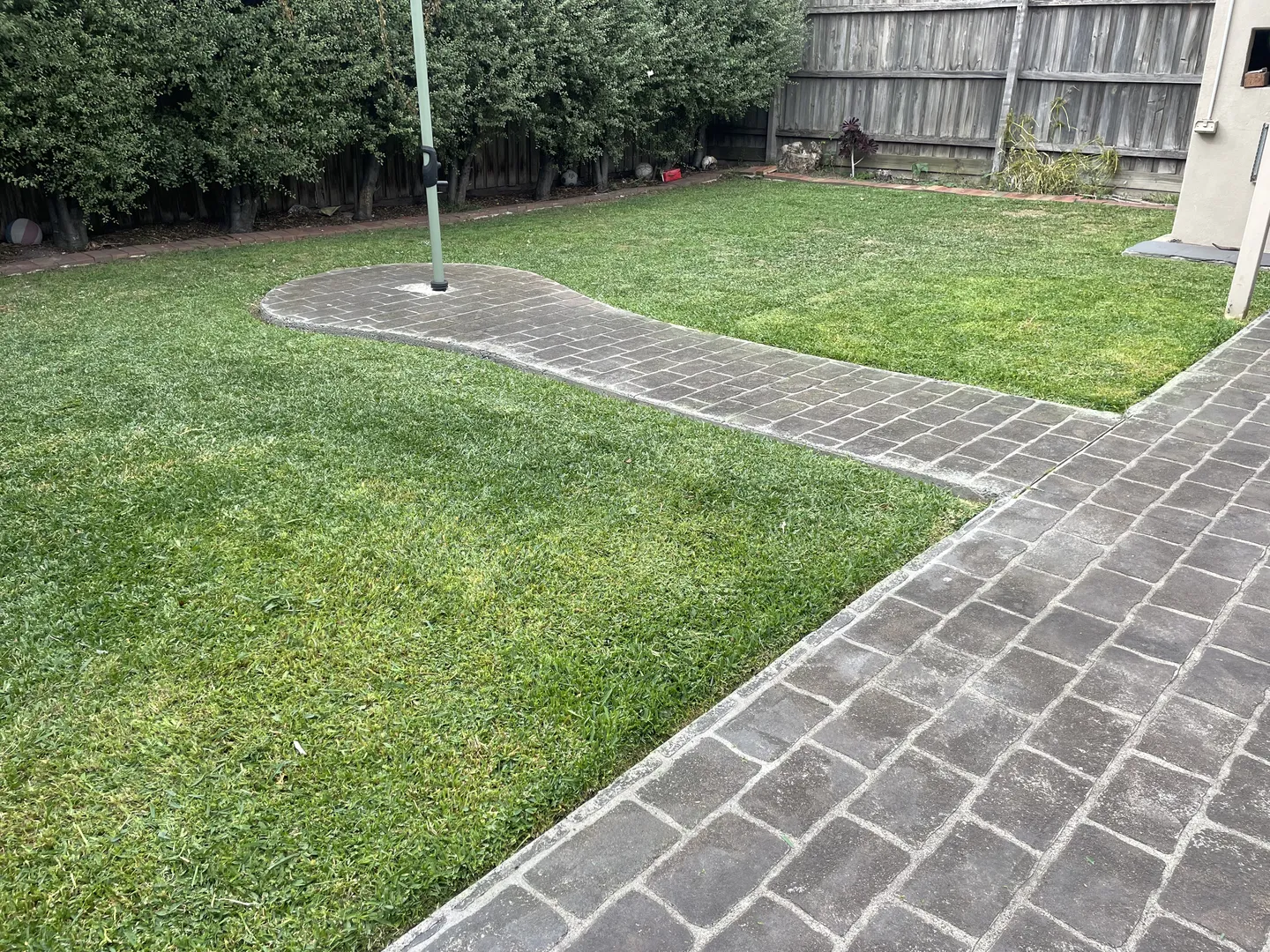 A residential backyard lawn showing short, level green grass after mowing